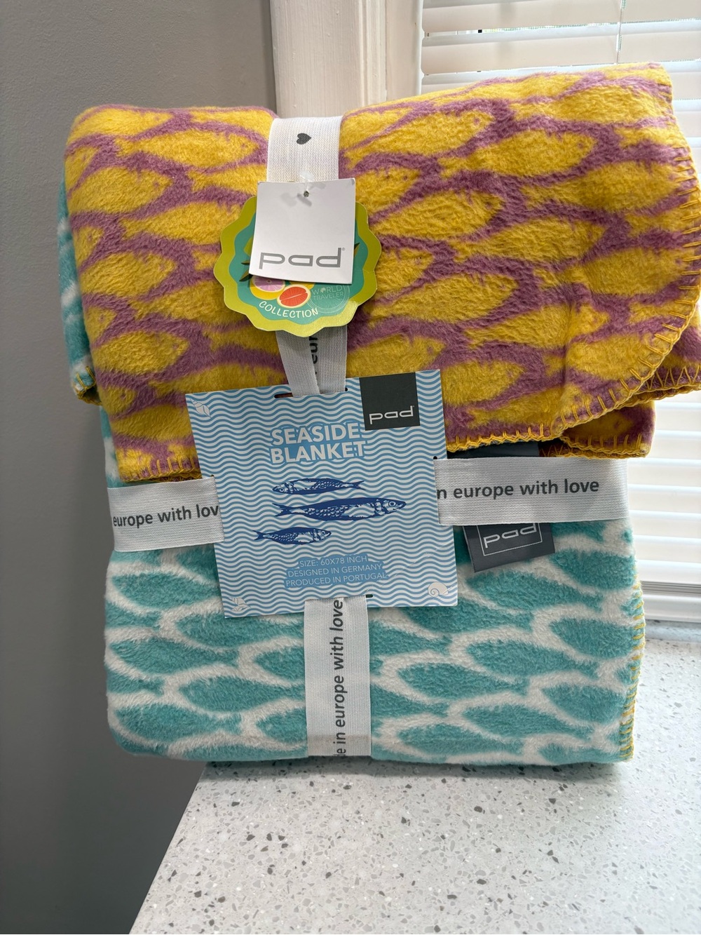 New in package Pad Seaside Blanket- multi color featuring coastal fish